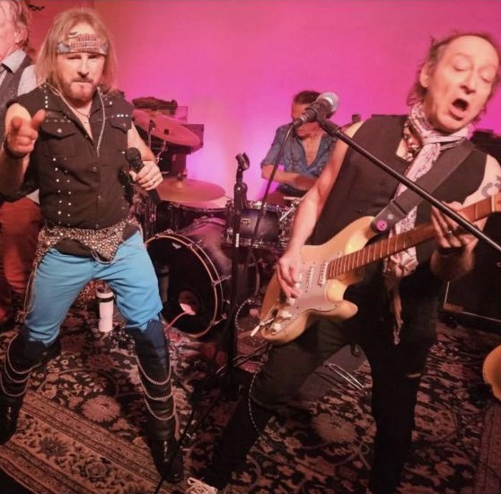 Rock of Ages on stage: the singer points at the camera while the guitarist plays a Stratocaster